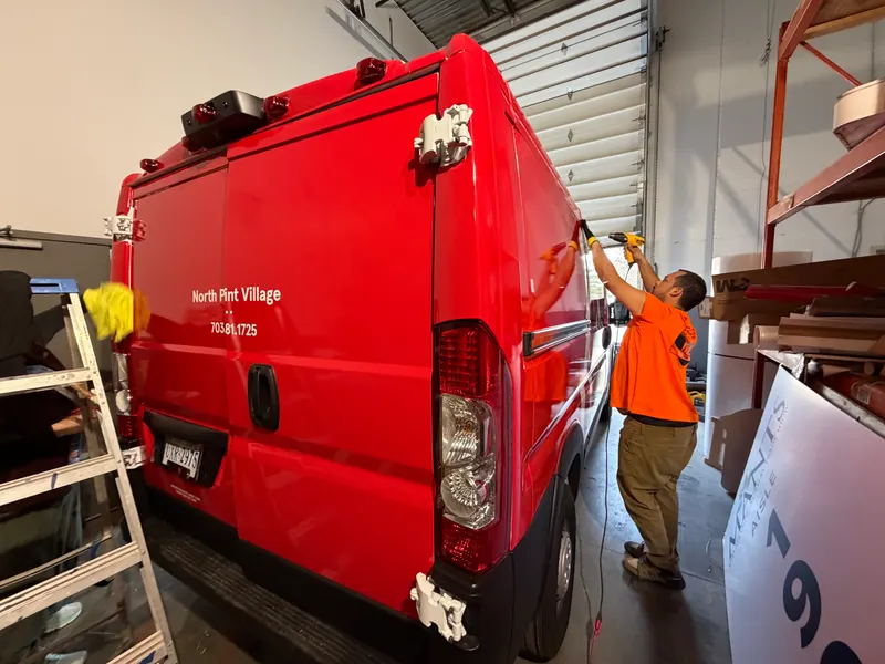 Installer applying door lettering to a commercial van