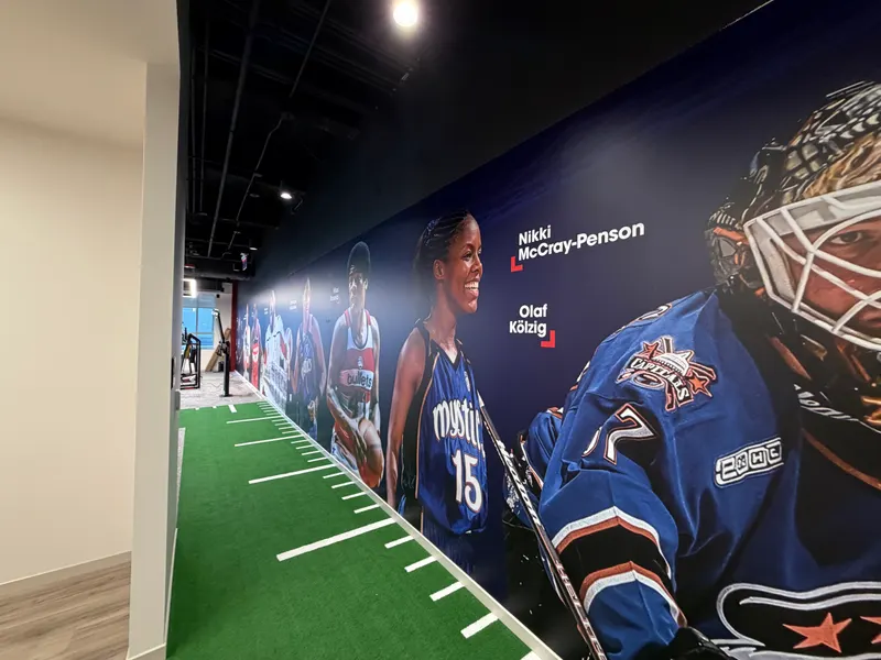 Finished athlete wall mural in a Monumental Sports training hallway